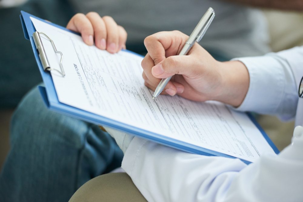 hands-unrecognizable-female-doctor-filling-form-clipboard